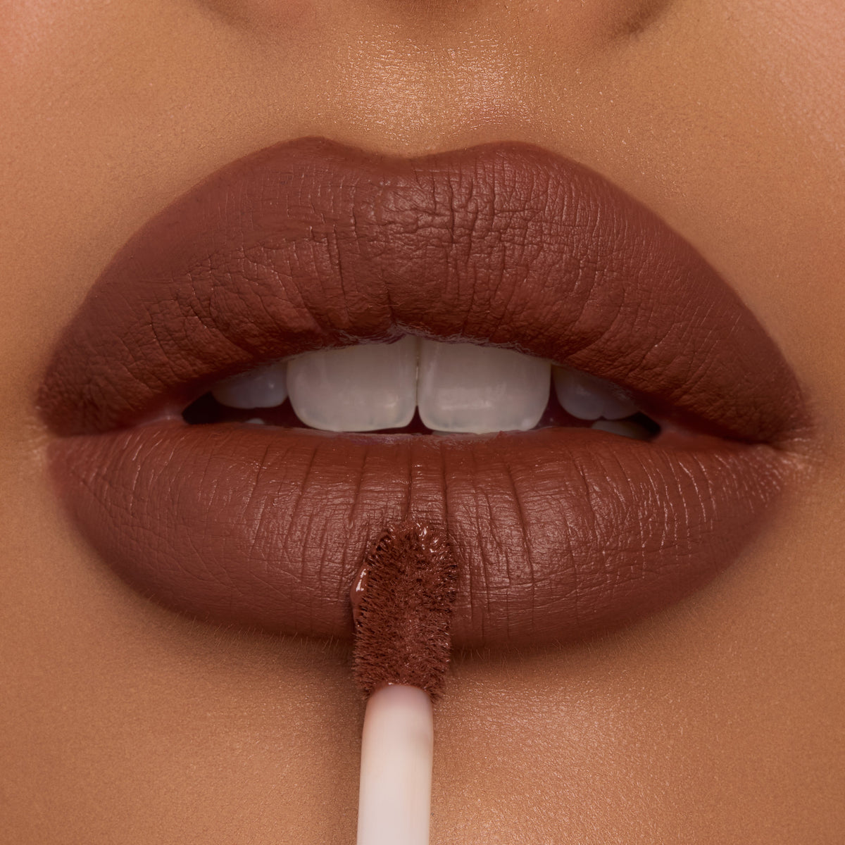 Full lips apply Espresso Martini Ultra Blotted Lip with a doe-foot applicator, revealing a soft-matte, blurred finish in a rich cocoa-brown shade; close-up of ColourPop Ultra Blotted Lip on warm skin.