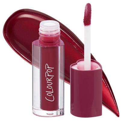 Blueberry Marg ColourPop Lip Stain stands uncapped, doe-foot applicator coated in a rich berry-wine shade beside a glossy swatch, showcasing the clear tube and plum cap on a clean white background.