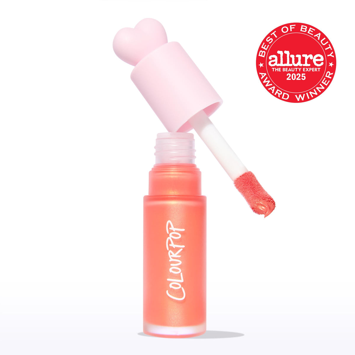 ColourPop Liquid Blush in Perfect Peach, doe-foot applicator lifting from a frosted coral tube with a pink heart-shaped cap, revealing a warm peachy tint; Allure 2025 Best of Beauty badge on a clean white background.