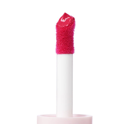 Doe-foot applicator coated in Wildest Dreams ColourPop Liquid Blush, a vivid hot-pink cream, held on a white wand with soft flocked tip against a clean white background, highlighting glossy, high-pigment texture for cheeks.