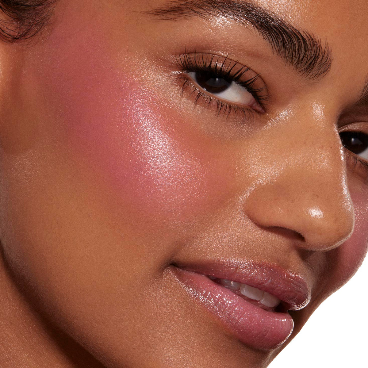 Sweet Treat ColourPop Liquid Blush tinting a model’s cheek with a dewy, luminous pink flush, seamlessly blended along the cheekbone; tight close-up shows smooth skin, glossy lips, and defined lashes for context.