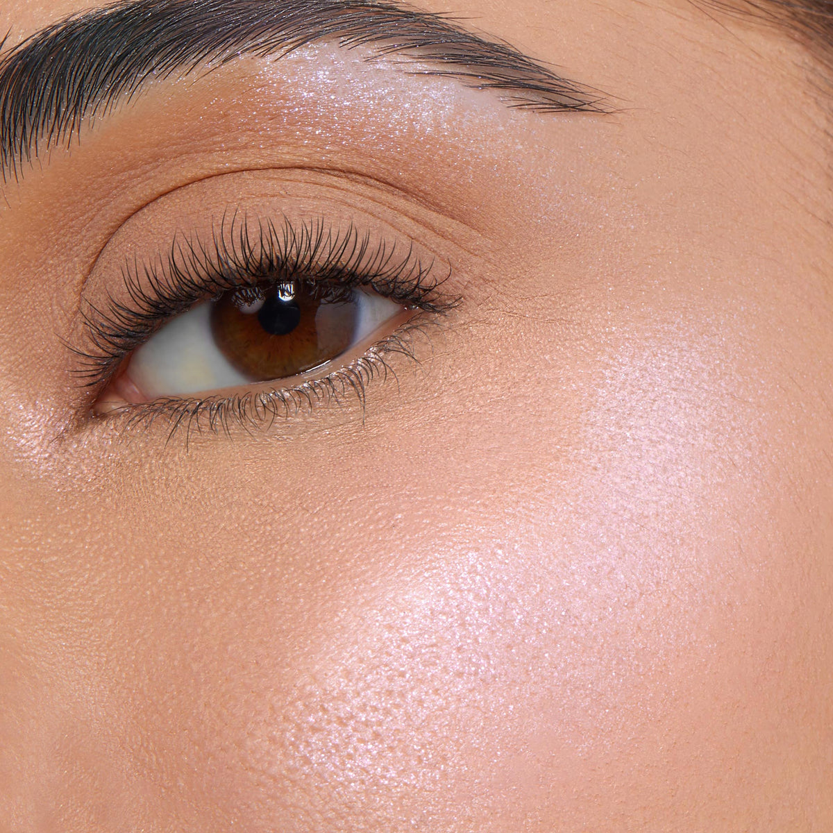 Meadow ColourPop Super Shock Highlighter illuminating the cheekbone and brow bone with a soft pink‑pearl glow in a close-up on-face swatch, showing smooth skin, defined lashes, and a natural, dewy finish.