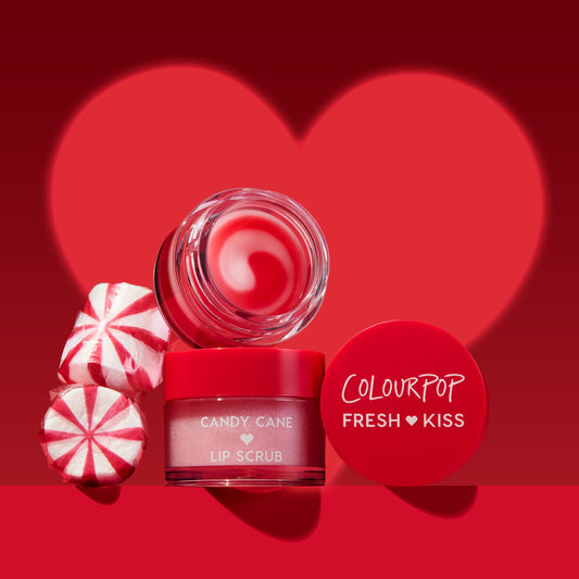 Red lip scrub with peppermint candies on a red heart-shaped background, featuring the ColourPop brand.