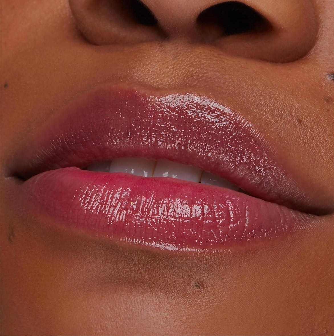 Glossy lips wear Thunderbolt pH Lip Balm, showing a sheer berry-pink tint that adjusts to pH with high shine; close-up swatch for ColourPop pH Lip Balm shade reference.