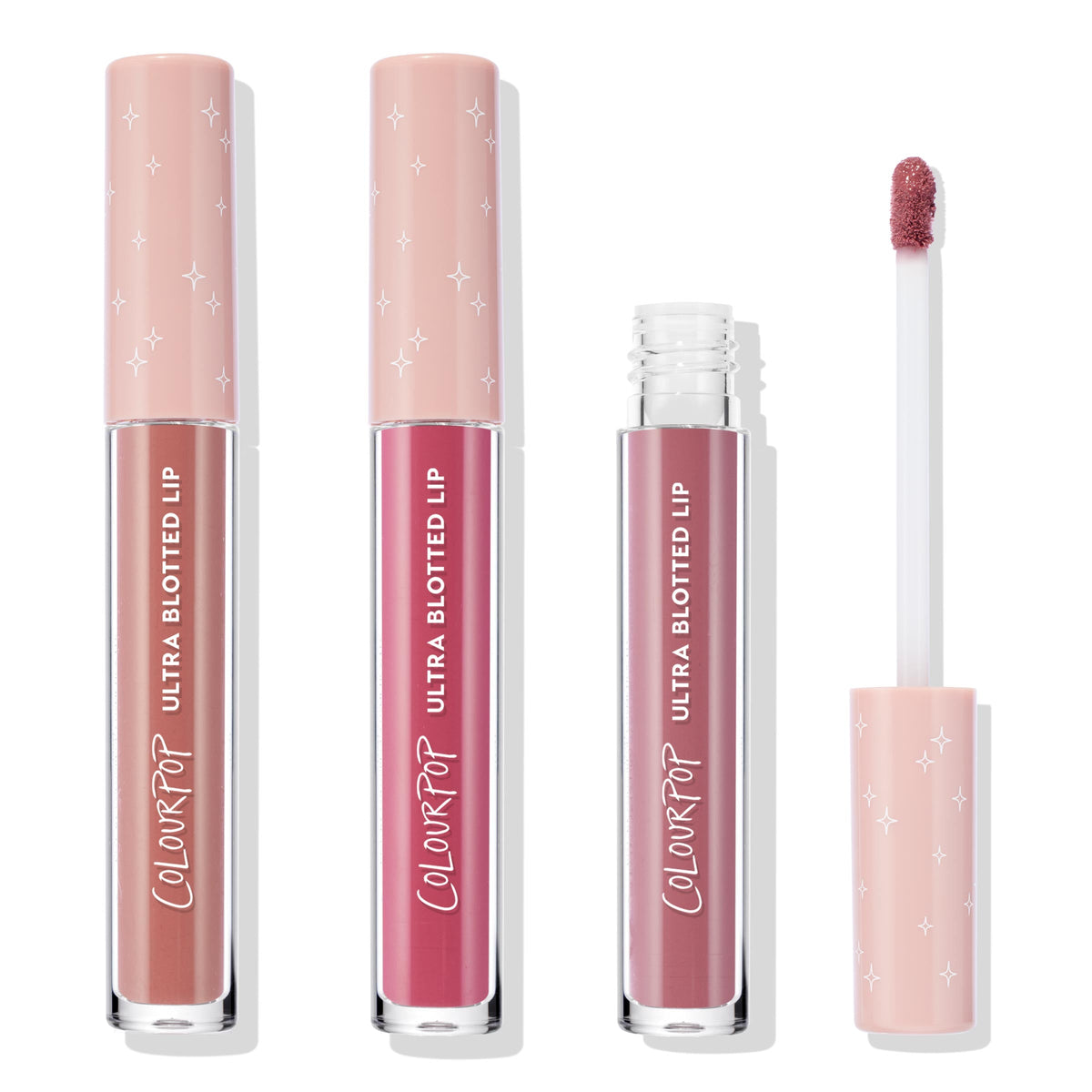 Perfect 4 U ColourPop Ultra Glossy Lip trio stands upright with one tube opened, a doe-foot applicator showing rosy mauve; clear barrels and blush-pink caps with white stars display nude, pink, and mauve shades on a white studio background.