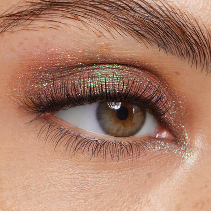 Shimmer-dusted eyelid wears Rooftop Cocktails, a rose-to-mint duochrome from the ColourPop Super Shock Shadow line, catching light across the lid while defined lashes frame the eye in a tight beauty close-up.