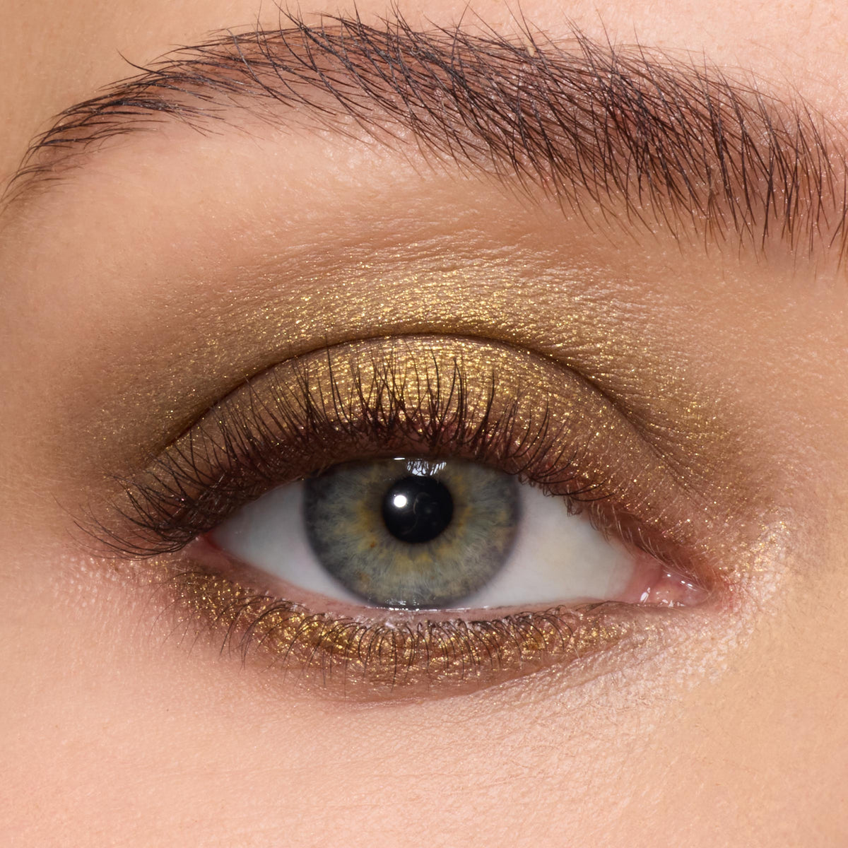 Metallic olive-gold shadow sweeping across the lid and lower lash line, showcasing the creamy payoff of ColourPop Super Shock Shadow We Won’t Bite on a close-up eye with soft lashes and a groomed brow.