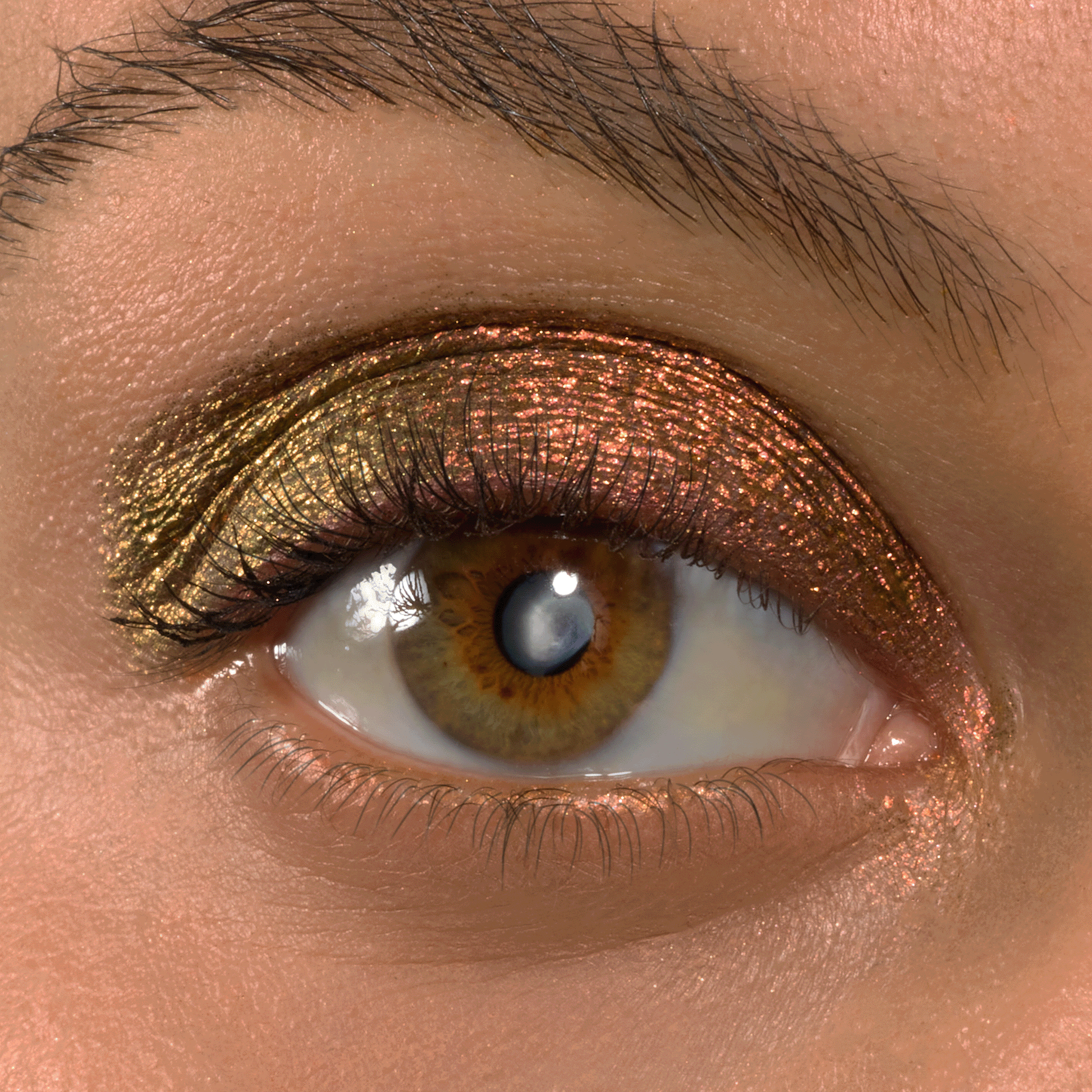 Metallic duochrome eyeshadow shifts from olive gold to copper on a hazel eye, applied across the lid with Wolf Girl Shadow Stix; lashes and brow visible, highlighting the shimmer finish of the ColourPop Shadow Stix.