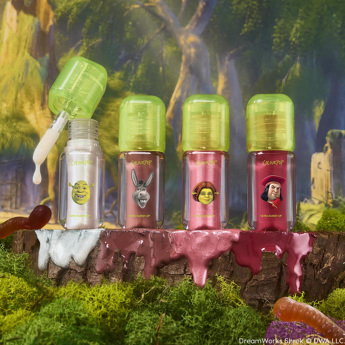 Totally Swamped ColourPop Ultra Glossy Lip set displays four mini tubes with neon green caps - Shrek, Donkey, Fiona, and Lord Farquaad - as a wand drips pearly shimmer, with rosy, bronze, and red glosses on a mossy log in a swamp backdrop.
