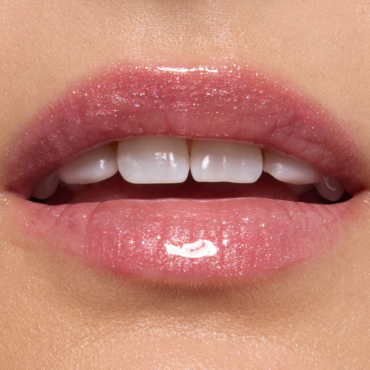 Glossy lips wearing ColourPop Ultra Glossy Lip in Totally Swamped, a sheer pink shimmer with fine sparkle, reflecting high shine in a studio close-up to showcase the smooth, hydrated finish.