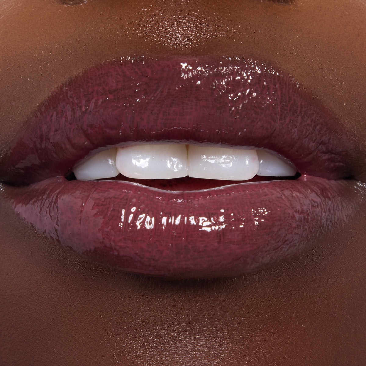 Glossed lips showcase ColourPop Ultra Glossy Lip in Short Lord, a deep berry‑plum shade with glassy, full‑coverage shine, applied evenly on smooth lips; tight macro shot highlighting the reflective finish for a product swatch.
