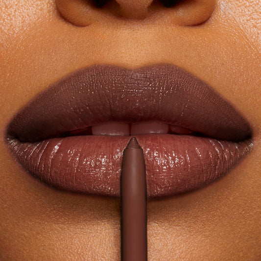 Close-up lip liner pencil defining glossy, full lips in a rich mocha-brown; precise application of ColourPop So Juicy Plumping Lip Liner with Peptides, Mocha Latte, creating smooth, contoured edges and a plumped finish.