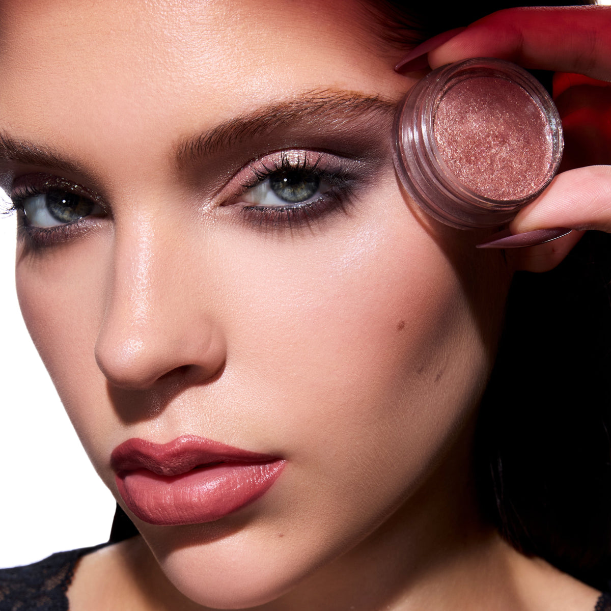 Model holds ColourPop Coven Clash Jelly Much Duo near her temple, showcasing shimmering rose Twilight eyeshadow on lids with smoky detail and matching mauve lips against a clean studio background.