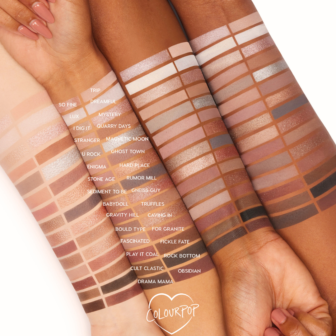 The Ultimate Stunner ColourPop Shadow Palette & Brush Set swatched on three arms, showing cool-to-warm mattes and shimmers from ivory and taupe to rose, bronze, and deep charcoal, with labeled shade rows and a small ColourPop logo.