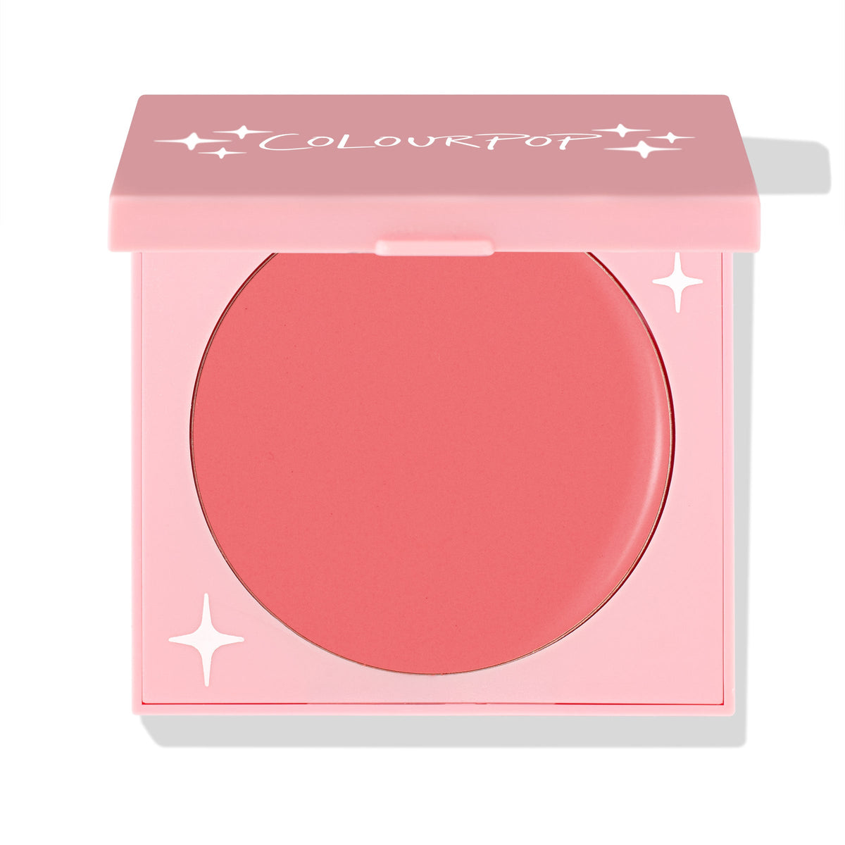 Whole Mood cream blush showing a warm coral shade as the pink compact with ColourPop logo sits half-open, revealing the round pan and star accents; studio close-up on white for ColourPop Cream Blush shoppers seeking a soft, natural flush.