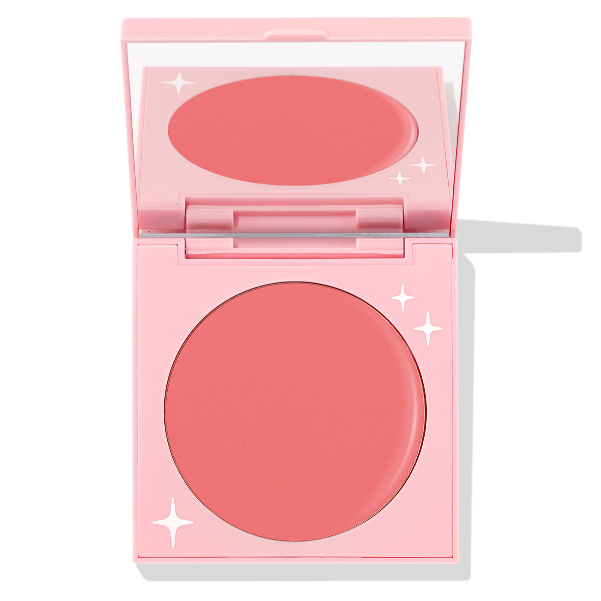 Whole Mood cream blush compact half-open, showing a round rosy-pink matte pan and mirror inside a pastel pink case with white star accents; ColourPop Cream Blush product.