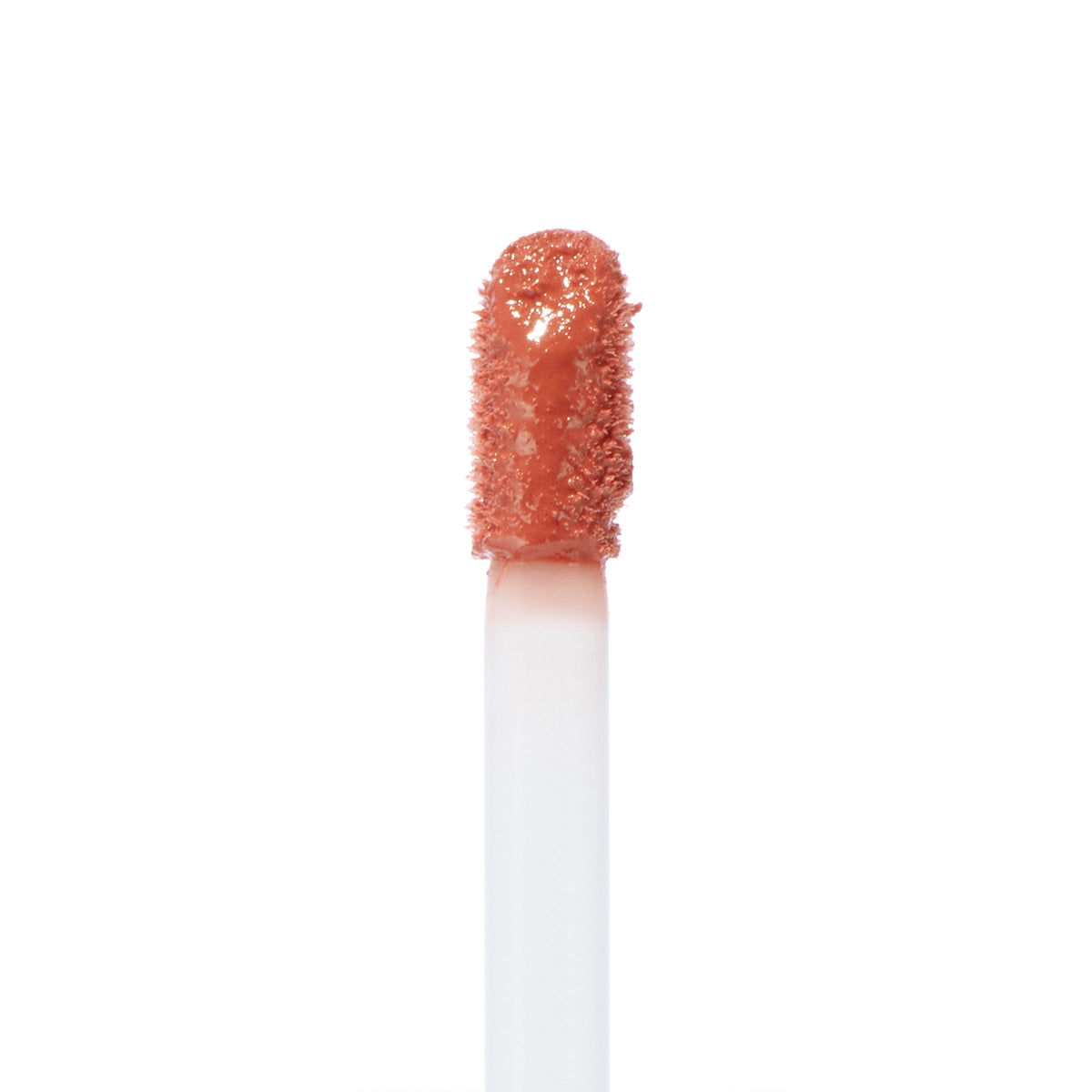 Doe-foot applicator coated in Zuma Ultra Blotted Lip by ColourPop, a warm peachy nude shade, captured in a crisp macro close-up against a clean white background.