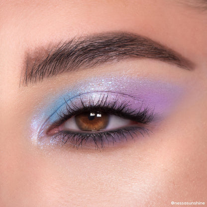 Pastel blue and lavender shimmer eyeshadow blends across a brown eye, showcasing the In A Trance ColourPop Shadow Palette with iridescent sparkle, tight-lined lashes, and a soft gradient finish in a close-up beauty look.