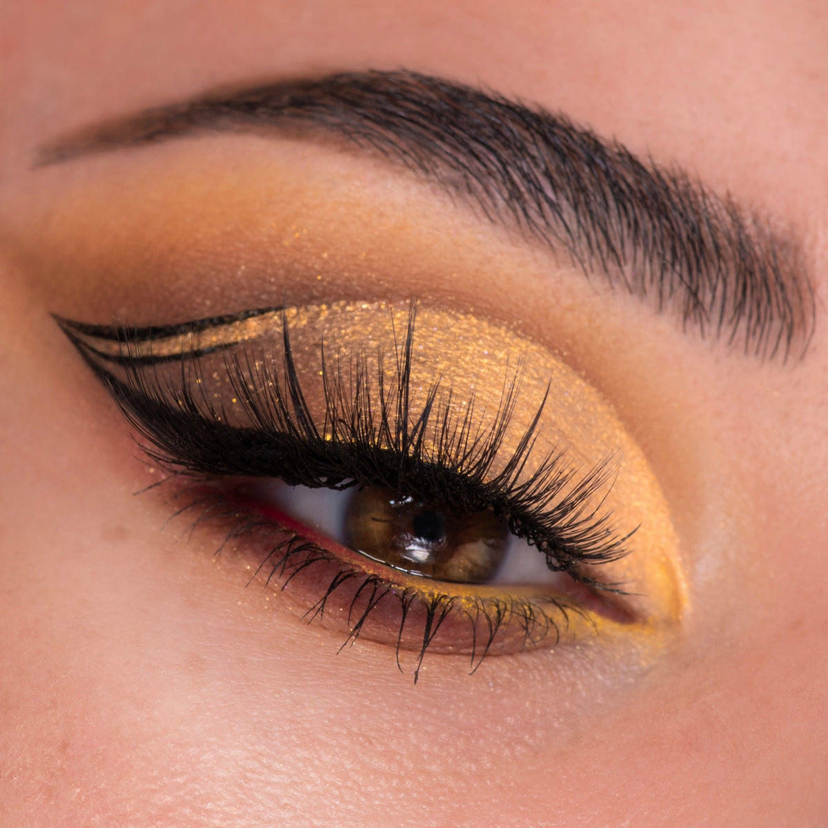 Close-up eye wears golden honey shimmer shadow with precise black double-wing liner and full lashes, showcasing the Sweet as Hunny ColourPop Eye & Lip Set in a studio shot with warm yellow inner-corner pop and soft brown crease.