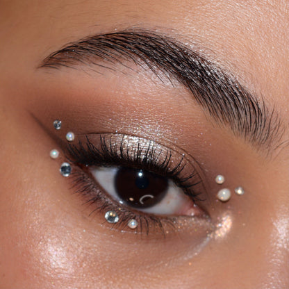 Eyelid wearing ColourPop Feelin' Bubbly shadow palette, shimmering champagne lid with matte taupe crease and soft wing; defined lashes, tiny pearls and rhinestones dotted around the outer and lower lash line for a festive glam look.