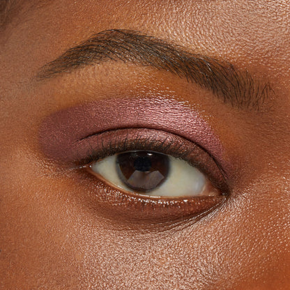Rosy-plum metallic eyeshadow sweeps across a model’s eyelid, showcasing So Into U ColourPop Shadow Stix with smooth, blendable coverage and a high-shine finish in a close-up beauty swatch.