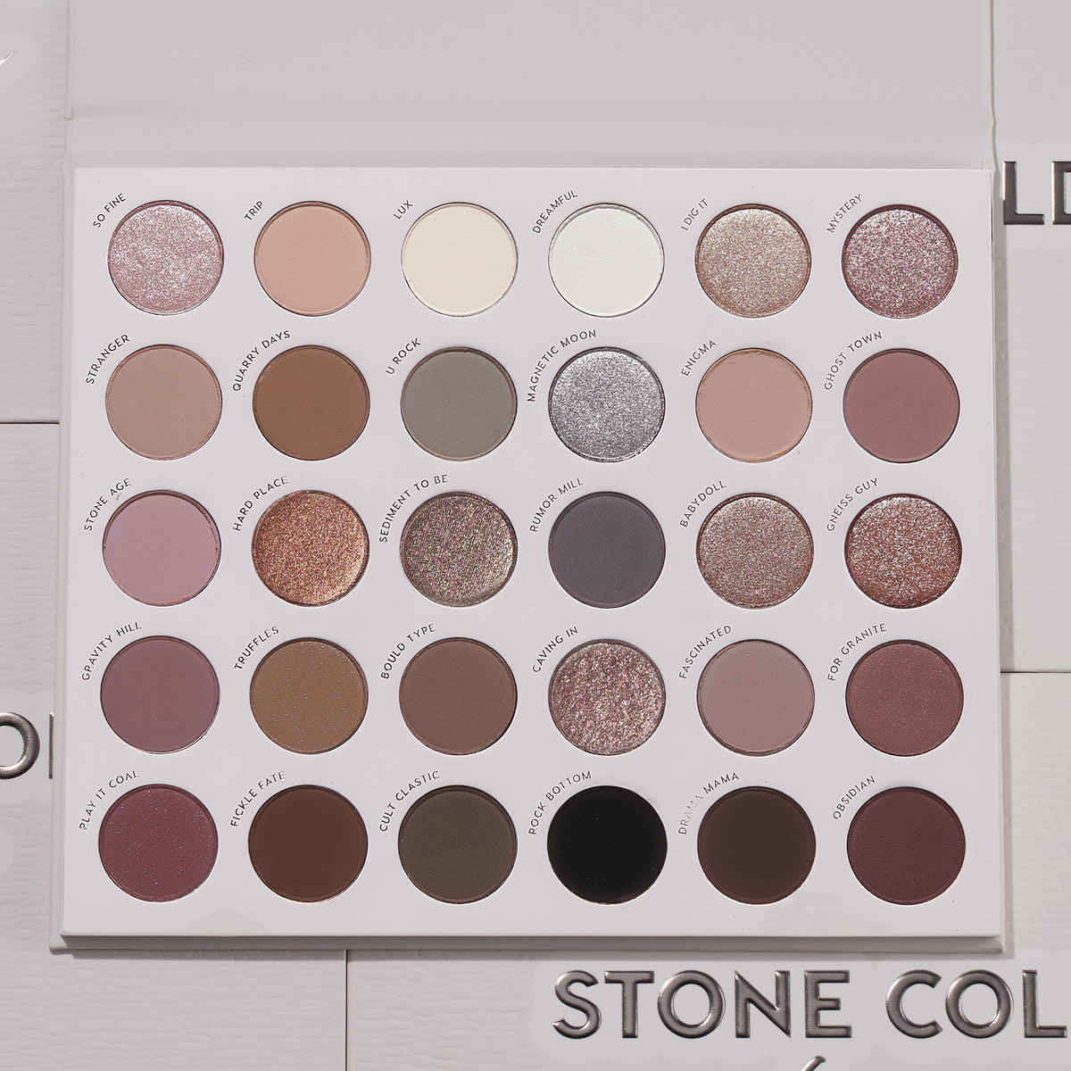 Bold + Bare ColourPop Shadow Palette Set presents an open 30-pan cool‑toned eyeshadow palette with matte and shimmer taupes, mauves, grays, silvers, plum and black, arranged in neat rows on a white tray, lid open on a light textured surface.