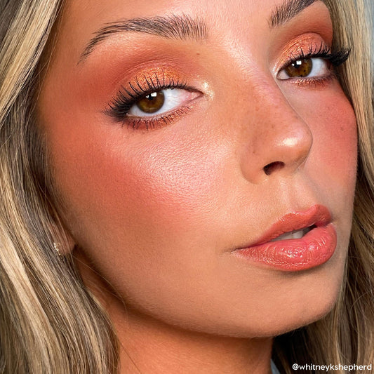 Rock On ColourPop Shadow Palette creating a copper shimmer eye on a model, blending warm terracotta in the crease with a bright inner-corner highlight, paired with long lashes, peach blush, and glossy nude lips in a studio close-up.